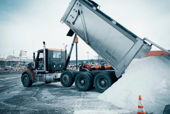 An Eastside Bulk dump truck with its body raised in the snow