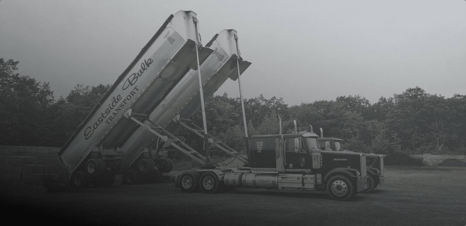Two Eastside Bulk Transport end-dump trailers raised in the yard