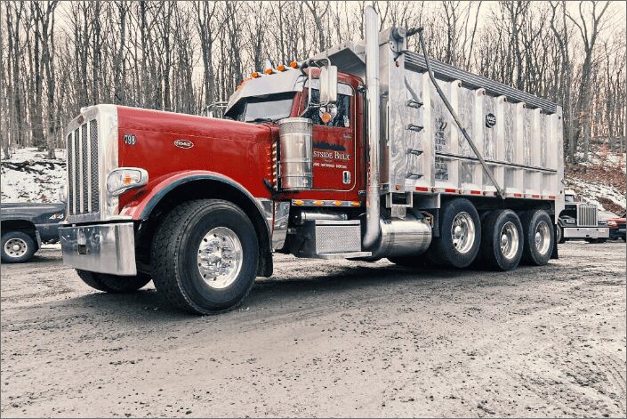 A red Eastside Bulk tri-axle dump truck