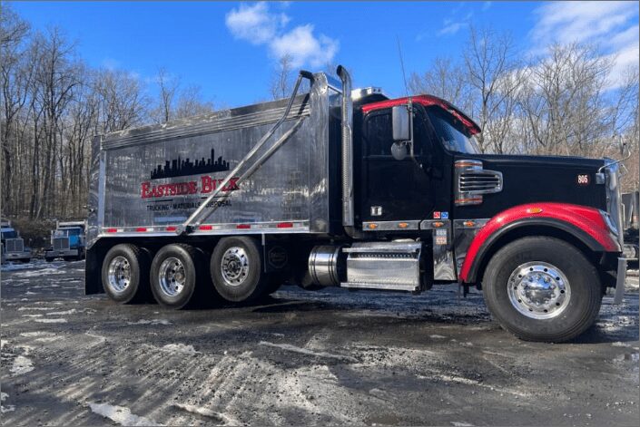 A black and red Eastside Bulk tri-axle dump truck